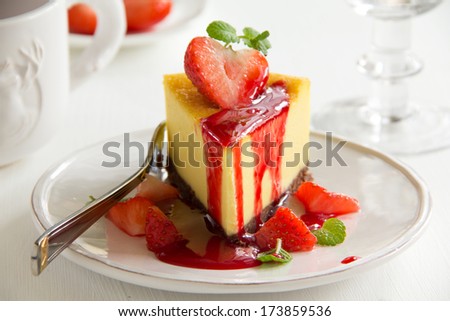 Slice of cheesecake with strawberries and strawberry sauce.