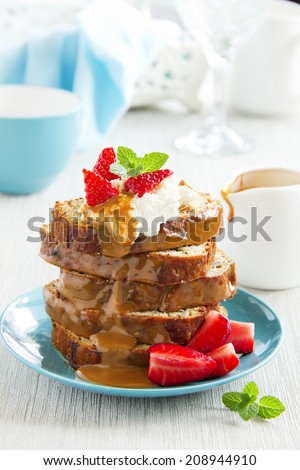 Dessert of banana cake with caramel sauce and strawberries.