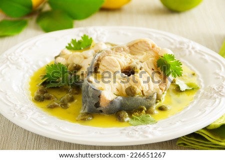 Hot lunch vapor sturgeon with lemon sauce and capers.