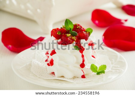 Meringue \'Pavlova\' with strawberries and strawberry sauce.