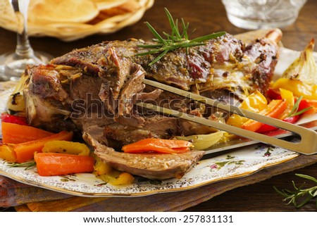 Roast leg of lamb with rosemary and garlic and vegetables.
