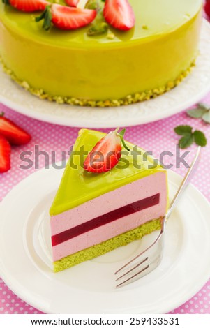 Delicious strawberry-pistachio mousse cake with a smooth glaze.