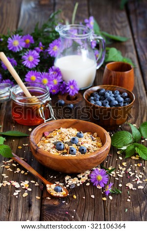 Healthy breakfast of granola with blueberries and nuts and milk. .