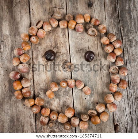 Sad face of acorns on a wooden background