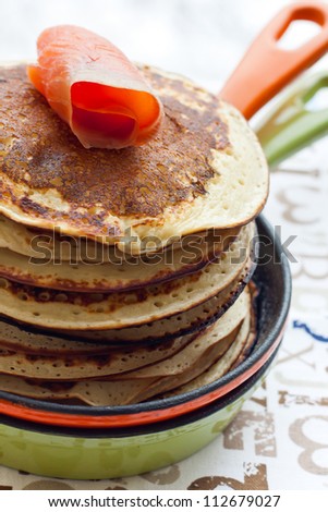 Stack of pancakes with smoked salmon on the pan