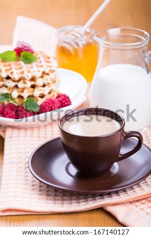 Fresh Belgian waffles with raspberries, honey and cup of coffee