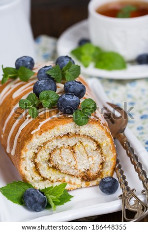 Sweet Biscuit Roll Cake with fresh berries and a cup of tea.