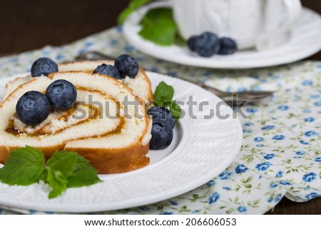 Sliced Sweet Biscuit Roll Cake with fresh berries and a cup of tea.