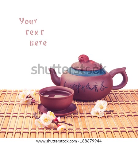 Tea ceremony. Tea set with sakura flowers on a bamboo mat, isolated on white background