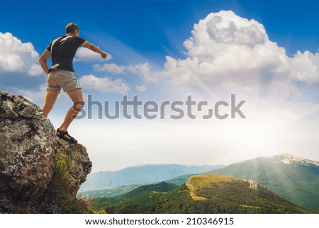Hiker standing on top of a mountain and points to the east