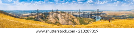 Panorama of Crimea mountain valley with woman-hiker and kid, who enjoy landscape