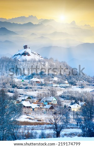 Winter sunrise above the mountain village covered with fresh morning snow