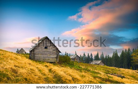 Sunrise above the nature wooden Ukrainian houses in a Carpathian mountains. Early morning, beginning of new day.