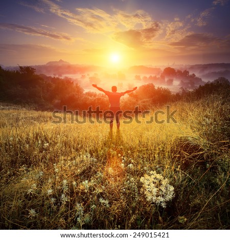 Men, who welcome sunrise with raised hands and enjoying landscape.