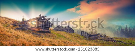 Panorama of beautiful sunrise in a rustic village with broken old wooden houses. Vintage colors