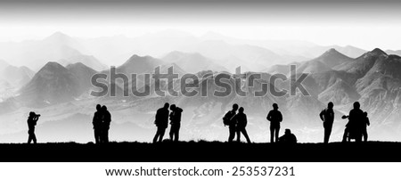 Silhouette of tourists in a high mountain valley. Travel team