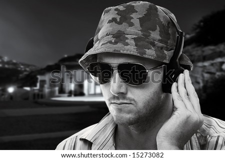 Shot of a DJ with Headphones to Ear playing Outside at Night