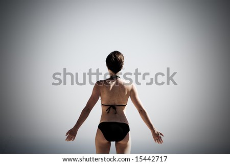 30s Woman with Arms Out, Looking out to a Hazy Sea