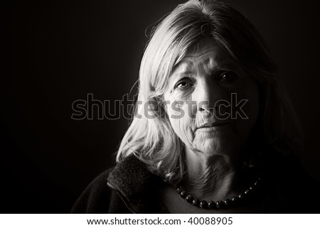Powerful Low Key Portrait of a Distressed Senior Lady