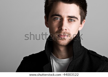 Striking Portrait Shot of a Handsome Dark Haired Male against Grey