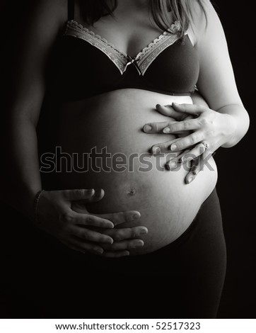 Beautiful Shot of a Mother and Father's Hands Supporting Pregnant Bump