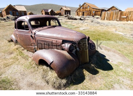 stock photo old rusted car in a town field