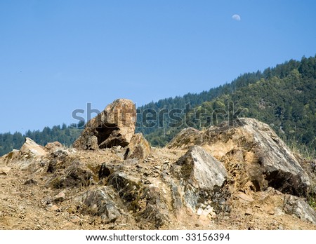 rock formation, moon and rolling green mountains