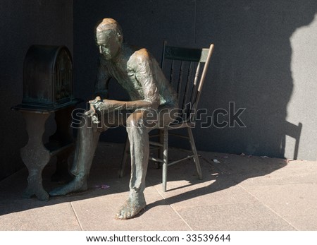 man listening to radio statue