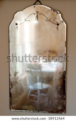 table and chairs reflected in an old mirror