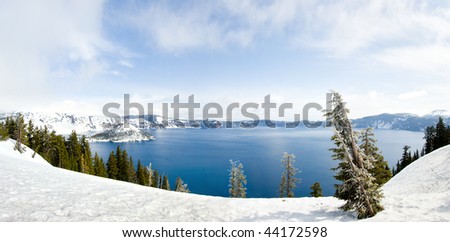 Crater Lake in winter with blue water, pine trees and Wizard Island