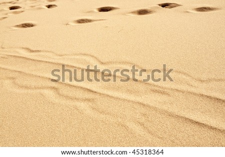 great sand dunes with sled tracks and footsteps in sand