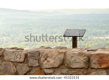 overlook of forested mountains and graffiti on rocks