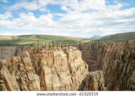 view of Black Canyon rocky cliffs and green plains
