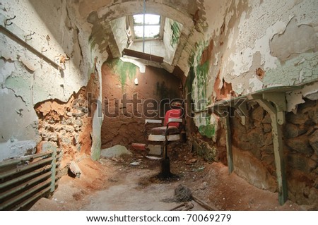 deteriorated prison cell walls and barber chair