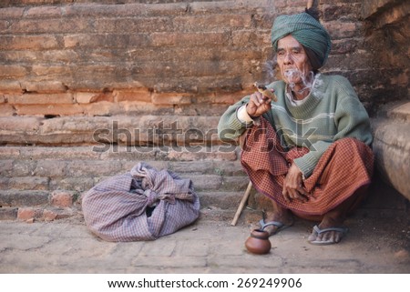 BAGAN, MYANMAR - DEC 18, 2014: Old wrinkled Asian man smoking traditional tobacco on December 18, 2014 in Bagan, Myanmar.