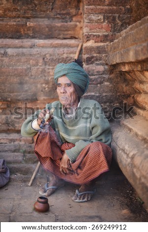 BAGAN, MYANMAR - DEC 18, 2014: Old wrinkled Asian man smoking traditional tobacco on December 18, 2014 in Bagan, Myanmar.