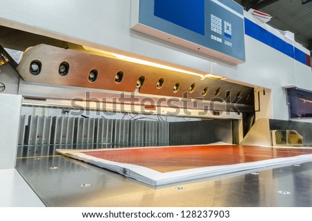 Front view of a modern paper guillotine with touch screen used in commercial printing industry (industrial knife cutter)