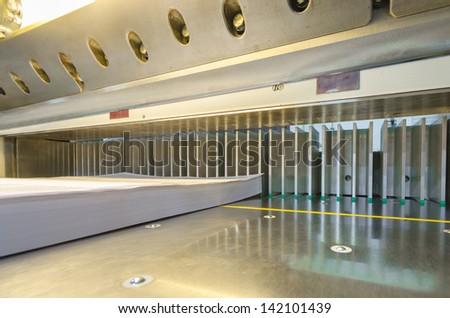 wide view of a modern paper guillotine with touch screen used in commercial printing industry (industrial knife cutter), ready to cut offset printed  magazine