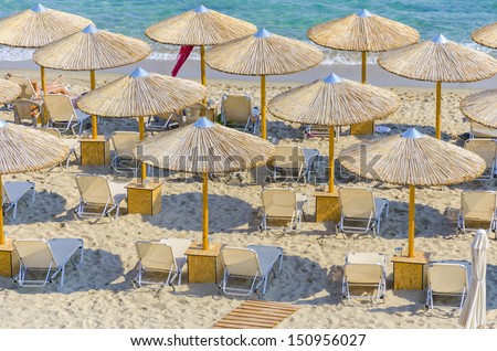 top view of beach straw umbrella making a nice pattern on crystal clear water ocean coast