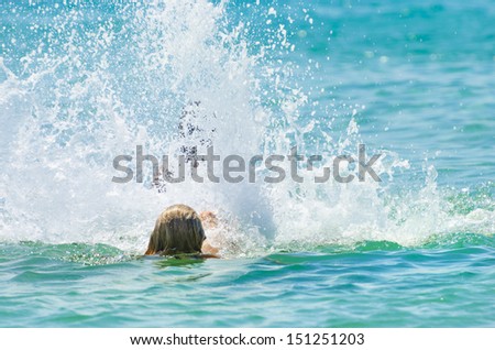 Back swimming. Young girl makes water splash on ocean, sea calm water back swimming