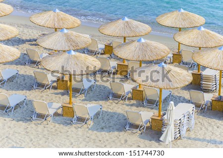 top view of beach straw umbrella making a nice pattern on crystal clear water ocean coast