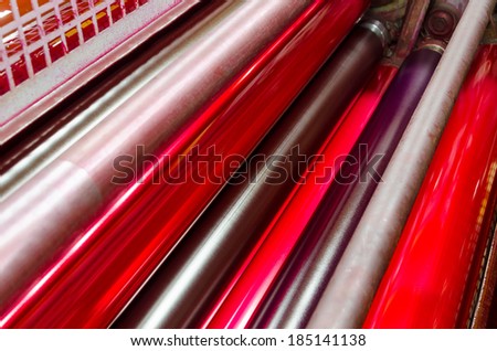 print machine printing press rollers, red magenda color drum, dramatic light