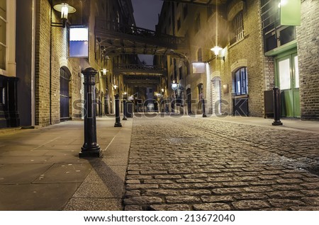 dark alley wide angle - Stock Image. London traditional old stone paved road at night VINTAGE
