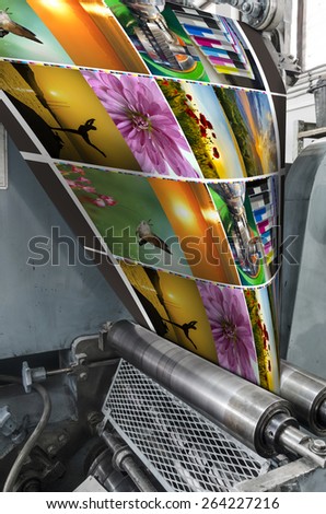 Large webset offset printing press running a long roll off paper over its rollers at high speed. VERTICAL