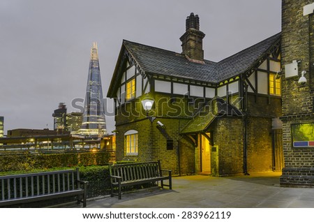old london house near Tower of London with view of The Shard at background. Night shoot, London, UK