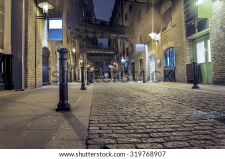 dark alley wide angle - Stock Image. London traditional old stone paved road at night