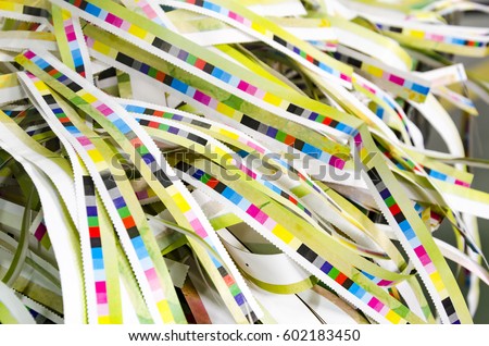 Prepress color management in print production. CMYK color stripes cut on printed paper. Quality printing concept