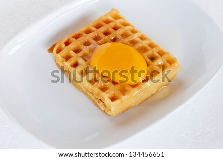 Waffle topped with egg yolk.