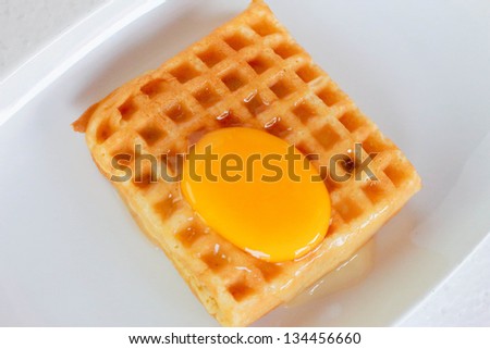 Waffle topped with egg yolk.