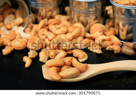 heap cashew nuts and salt on black background